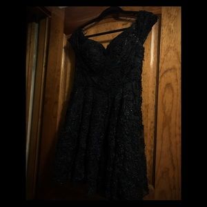 A black sequined off the shoulder dress